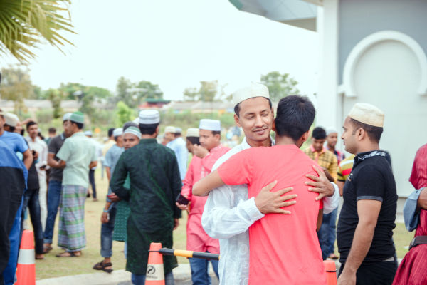 Due ragazzi bangladesi si abbracciano fuori da una moschea