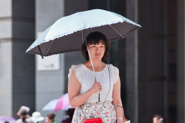 Donna cinese con ombrello sotto il sole