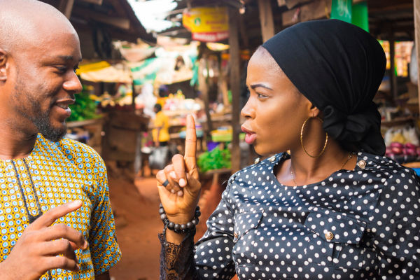 Due persone nigeriane che si guardano negli occhi mentre parlano