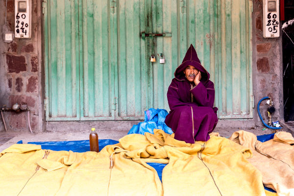 Uomo in attesa in un Souk a Marrakech, Marocco